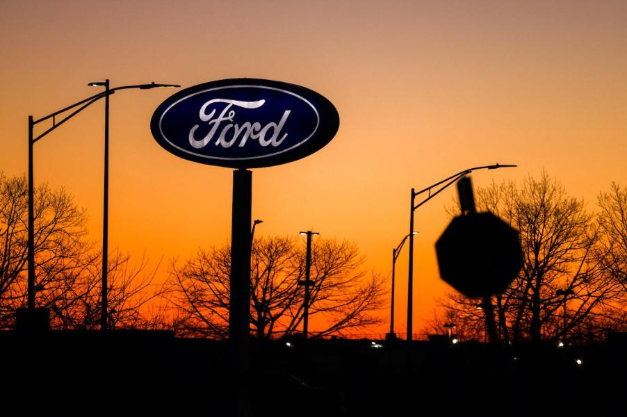 Ford logo outside a dealership, an orange sunset in the background.